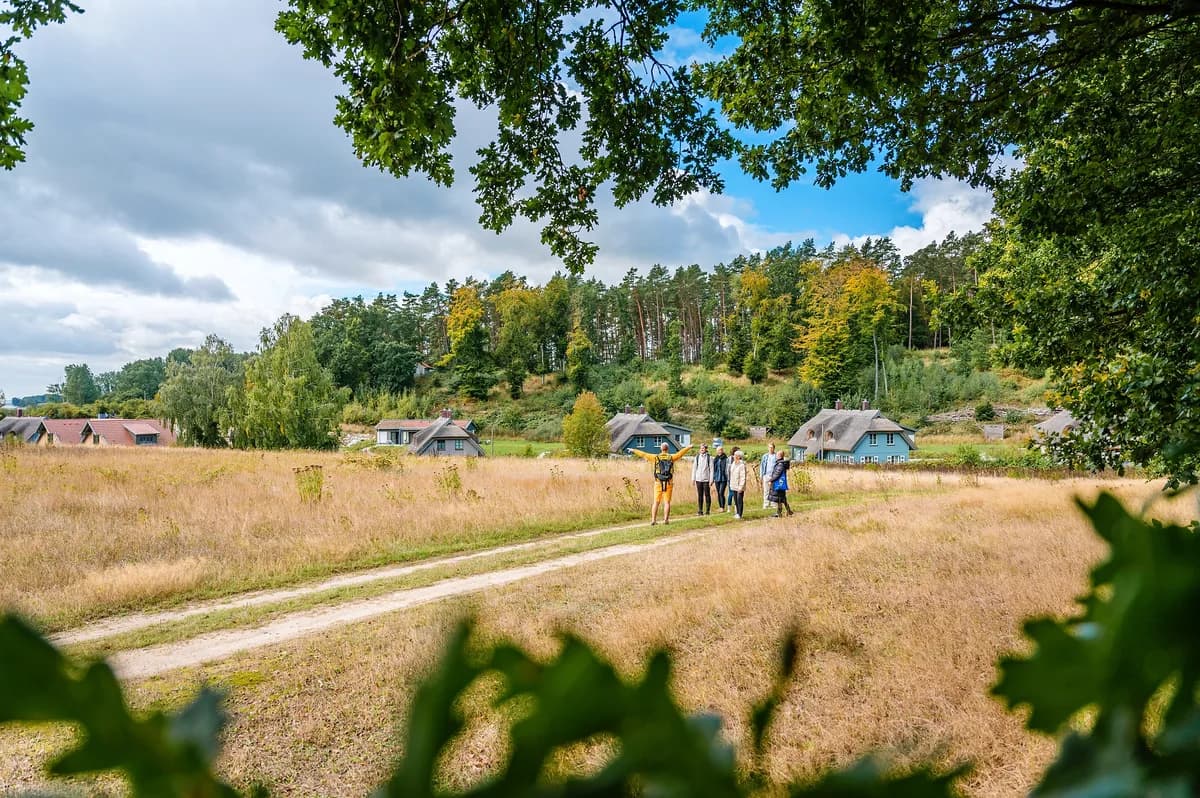 Feldweg durch die Wiesen zum Feriendorf Klein Stresow mit reetgedeckten Häusern