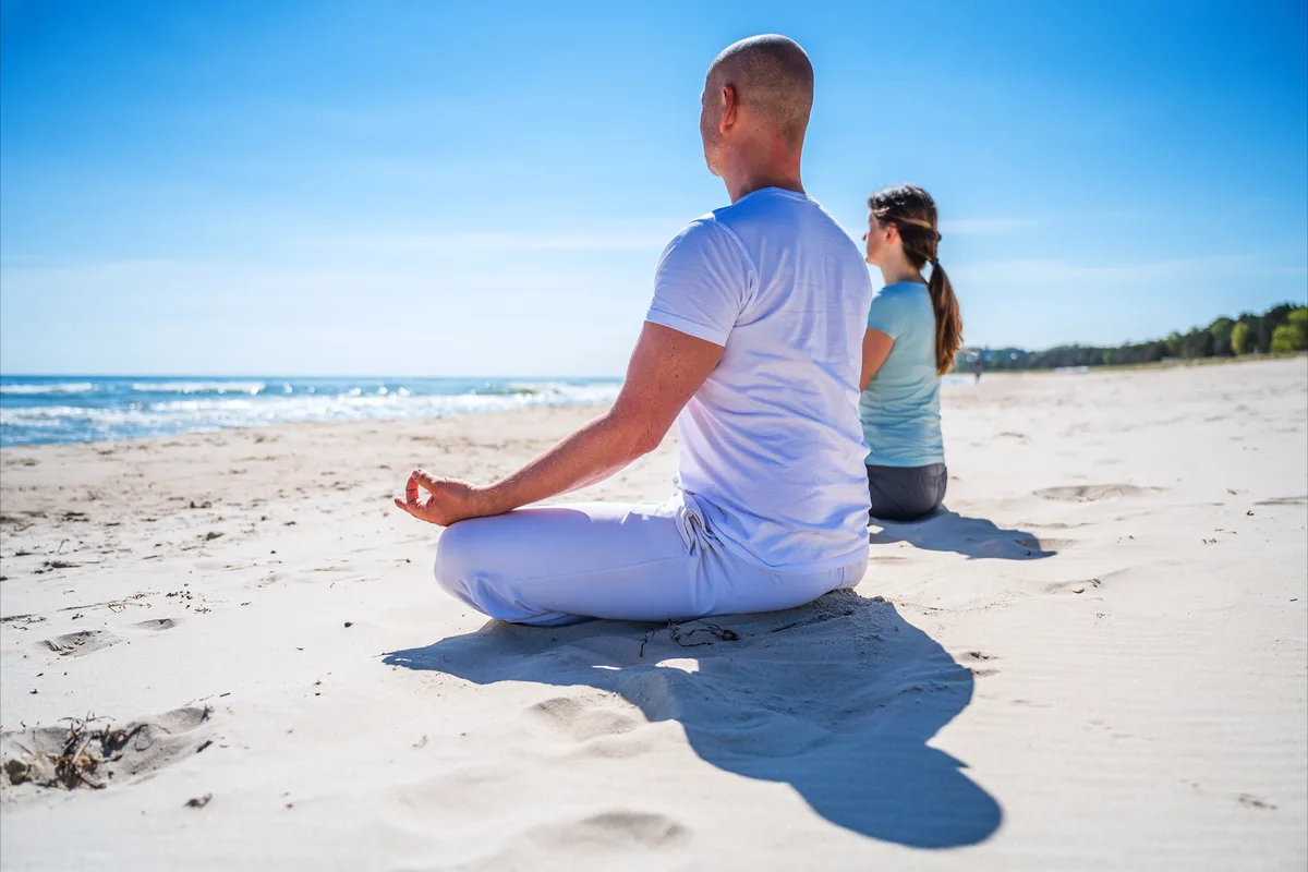 Meditation im Schneidersitz am Strand der Ostsee