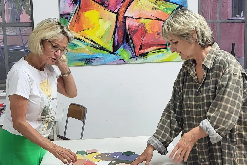 Janina Kracht bespricht mit einer Teilnehmerin eine Komposition aus Farbflächen im Atelier